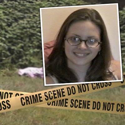 Crime scene tape in front of a covered body in a grassy location with a smiling brunette woman with glasses in the foreground